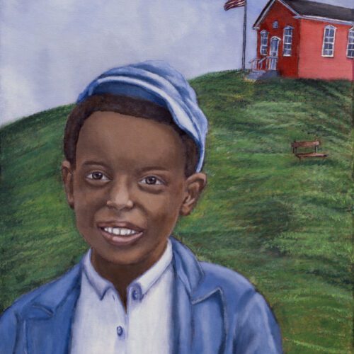 Young African American boy standing outside in front of a grassy hill with a red school house and American Flag in the background.